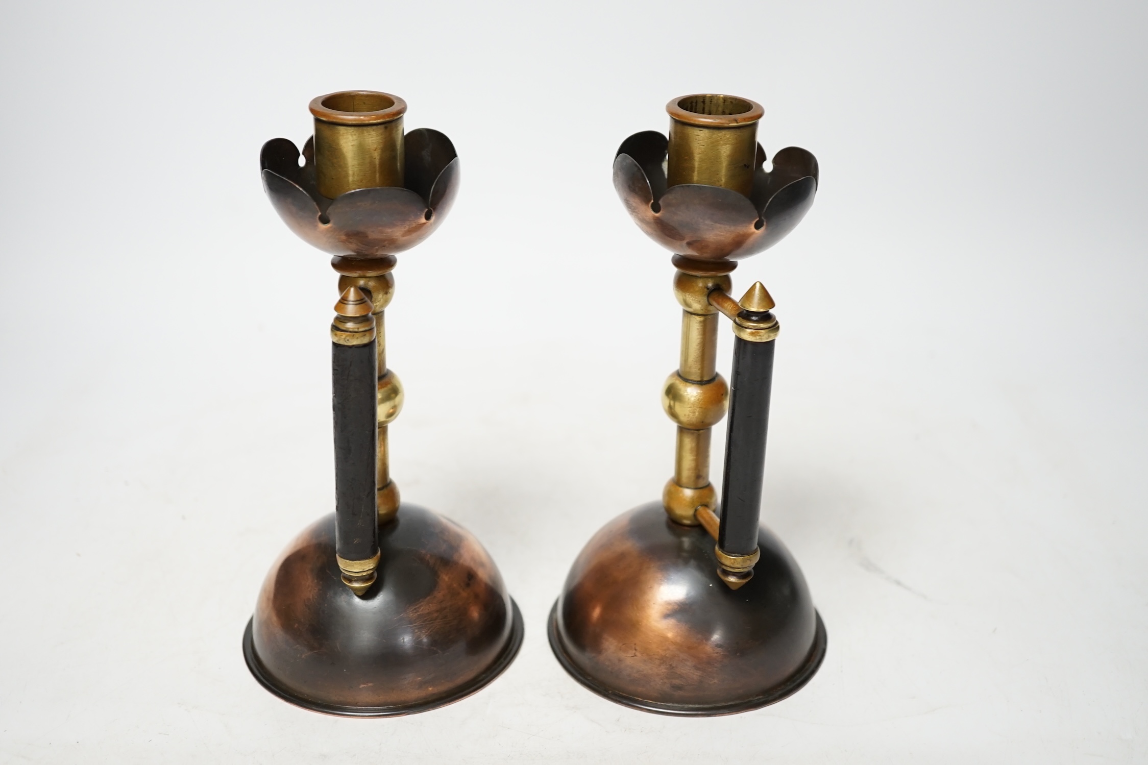 Christopher Dresser, a pair of copper and brass candlesticks by Benham and Froud, 18.5cm. Condition - fair